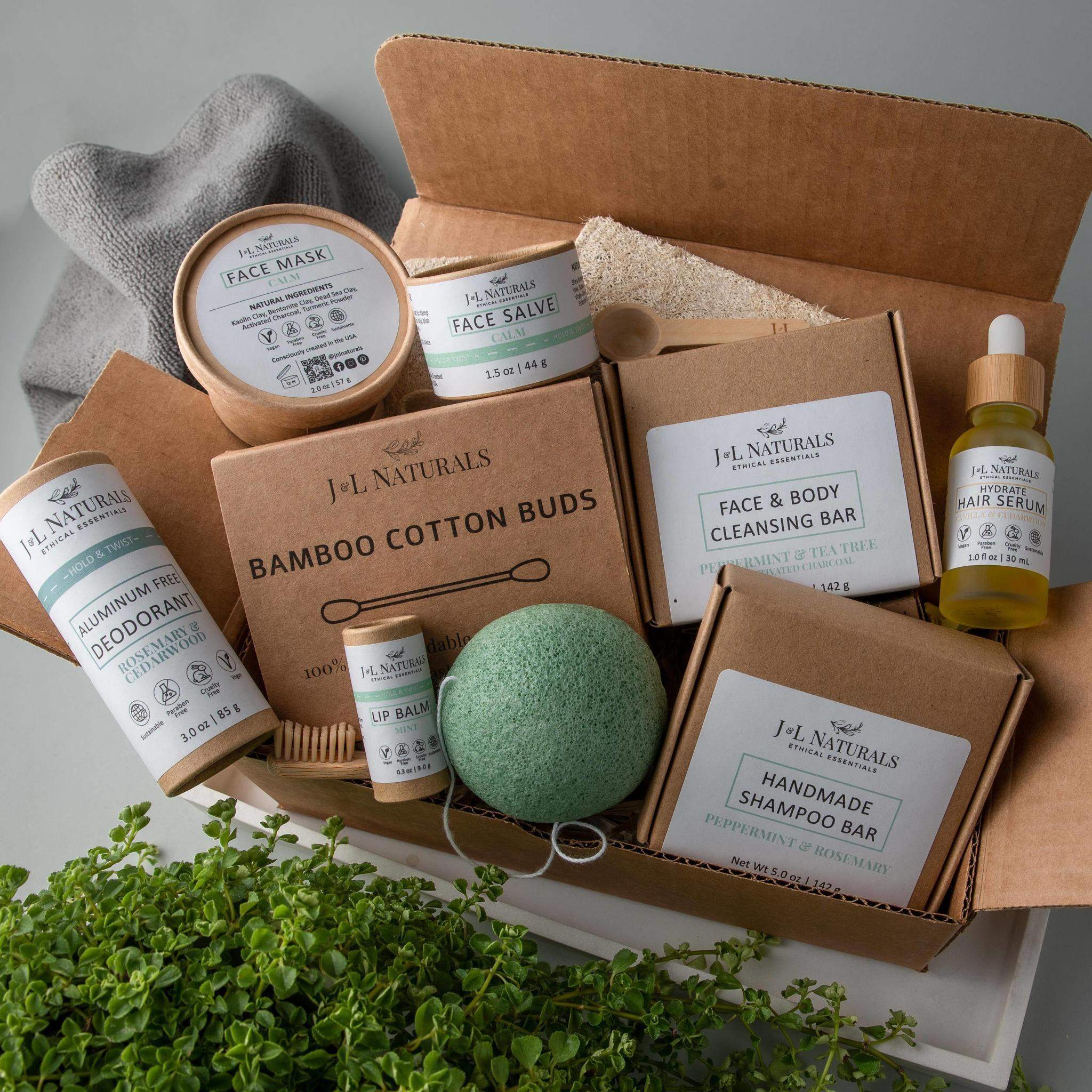 shessentials close up birds eye view shot bundle kit in box mage shows bamboo cotton buds, natural aluminium deodorant, shampoo bars, facial cleansing bars, lip balm, hair serum, face salves, bamboo toothbrush, charcoal floss and face mask