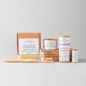 essentials kit with face and skin products in brown and turquoise packaging with whitish grey background