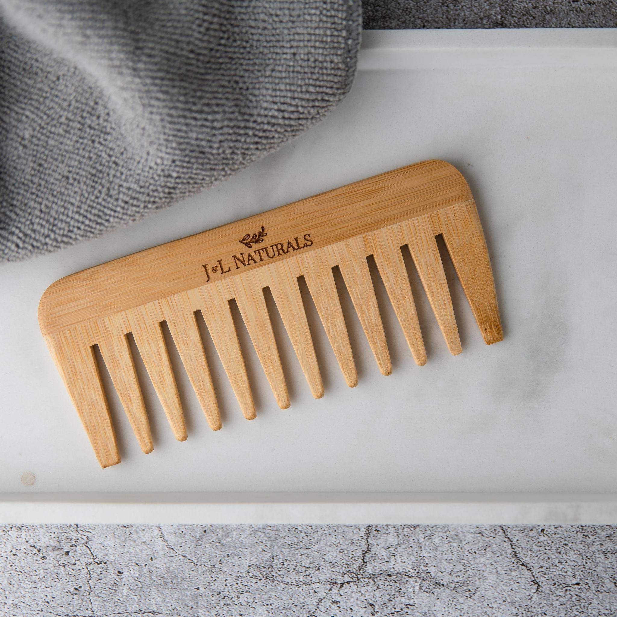 birds eye view shot of Wide Tooth Bamboo Detangling Comb in white and grey aesthetic backdrop