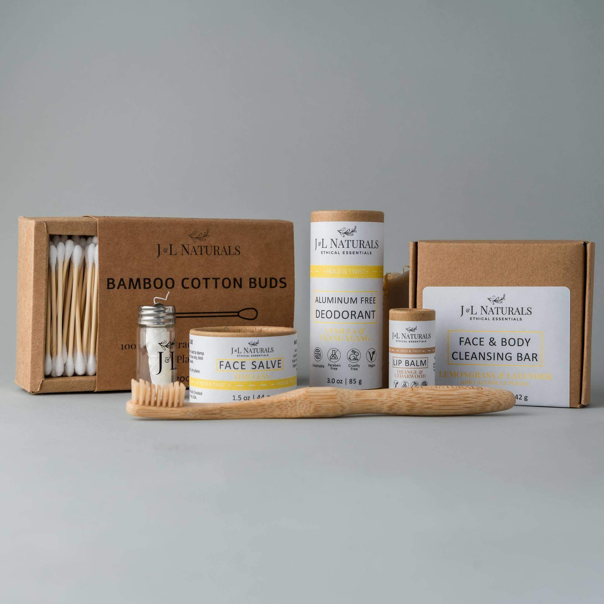 essentials kit with face and skin products in brown and yellow packaging with whitish grey background